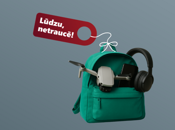 Zaļa mugursoma ar dronu, telefonu un austiņām, virs somas karājas sarkana zīmīte ar tekstu “Lūdzu, netraucē!”.